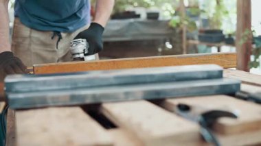 Bir işçi, çelik bir parçanın pasını öğütücüyle öğütüyor. Yakın plan..