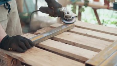 Bir işçi, çelik bir parçanın pasını öğütücüyle öğütüyor. Yakın plan..