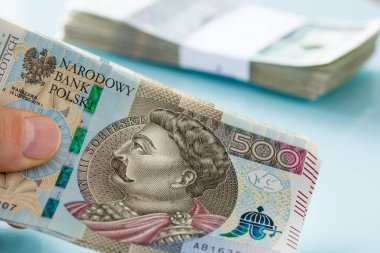 Büyük miktarda Polonya 500 zloti bandı arka planda tutuyordu. Bir tomar para bantla tutturulmuştu.