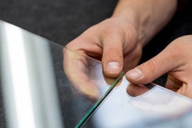 Camcı parmaklarındaki camı kırar.