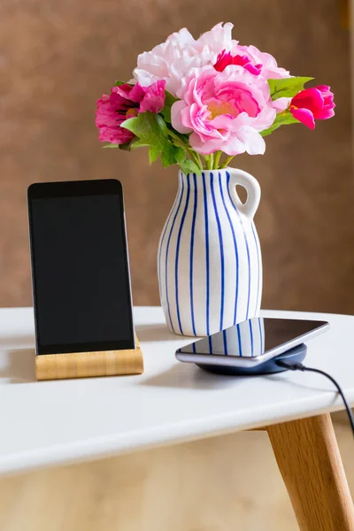 Teléfono Cargando Cargador Inalámbrico Pie Sobre Mesa Apartamento Junto Jarrón — Foto de Stock