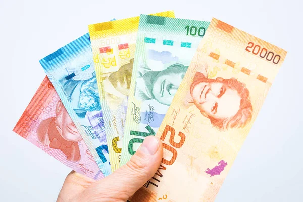 Kosta Rika parası, Colones, tüm banknotlar yayılmış ve beyaz arka planda bir erkek elinde tutulmuş.