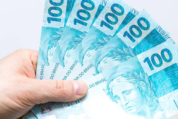 Brazilian Real. Money spread out in a fan, held in a man's hand