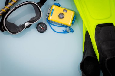 Mavi arka planda dalış ekipmanları. Su altı kamerası, yazı için yer. Scuba günlüğü