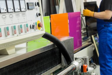 Camcı atölyedeki profesyonel bir öğütücüde renkli camları öğütüyor.