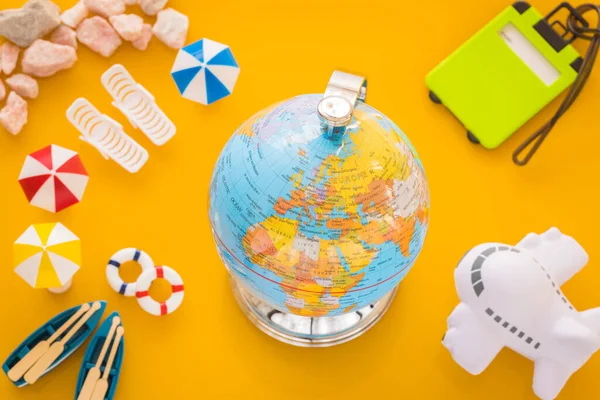 Miniaturas Equipamentos Praia Avião Globo Com Mapa Mundo Fundo Amarelo — Fotografia de Stock