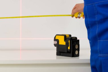 Kurucu, açıları ve düz çizgileri ölçmek için elektronik lazer kullanır.