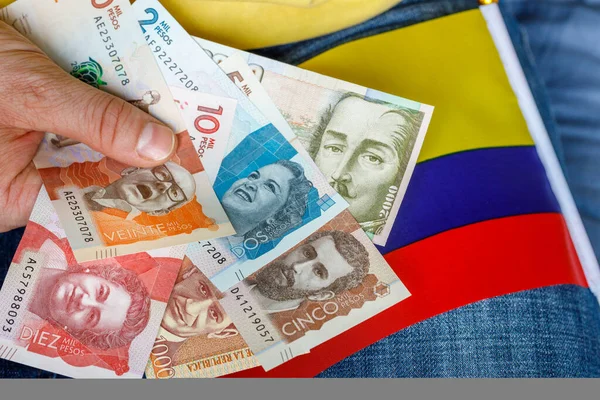 Kolombiya parası, pesolar, ulusal bayrak ile el ele tutuştular. Ekonomi kavramı 