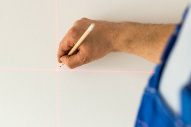 Yetenekli bir insan, duvarda elektronik lazerle işaretlenmiş bir nokta belirler. 