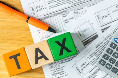 Hindistan, gelir vergisi iade formu. Finansal ve iş konsepti. Hint ulusal renkleri ve vergi kelimesi. Formlar, para ve hesap makinesi. Kapatın. Düz yatıyordu