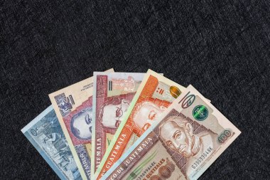 Guatemala money. Paper banknotes, Guatemalan quetzales bills arranged in a fan on a black background. Financial business concept. Flat lay, copy space. Close up