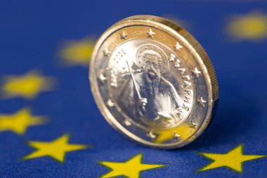 Avrupa Birliği bayrağına karşılık 1 avroluk yeni bir Bulgar sikkesi. Bulgaristan parası. İş ve finansal konsept. Avro bölgesinin Avrupa 'da genişletilmesi. Kapat.