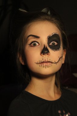 Cadılar Bayramı , tatil konsepti - kafatası siyah arka plan üzerinde makyaj ile genç küçük güzellik kız portresi