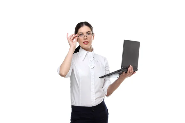 Le portrait d'une belle jeune femme d'affaires mince et souriante portant une chemise et des lunettes blanches et tenant un ordinateur portable dans sa main isolé sur fond blanc — Photo