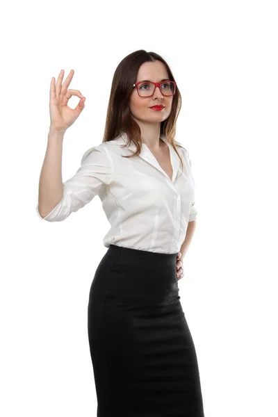 Le portrait d'une jeune femme d'affaires de mode adulte portant une chemise blanche, une jupe noire et des lunettes rouges montrant un geste isolé sur fond blanc — Photo