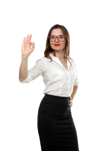 Le portrait d'une jeune femme d'affaires de mode adulte portant une chemise blanche, une jupe noire et des lunettes rouges montrant un geste isolé sur fond blanc — Photo