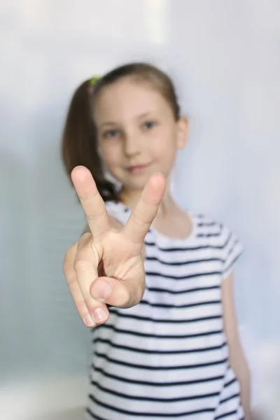 Portret młodej dziewczyny trochę sobie na paski t-shirt kciuki skrzyżowane się niewyraźne tło — Zdjęcie stockowe
