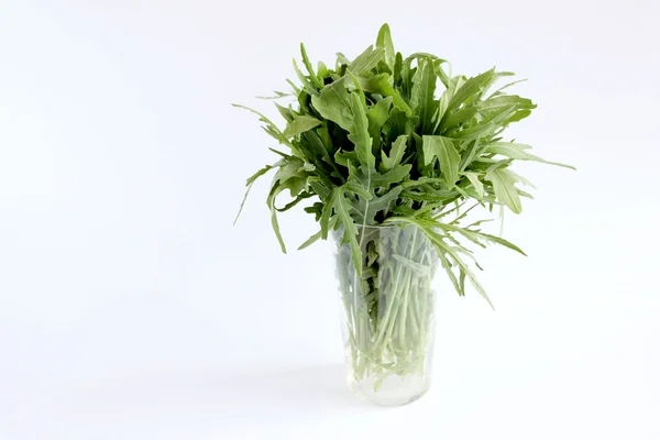 Grüner Rucola im Glas auf weißem Hintergrund — Stockfoto