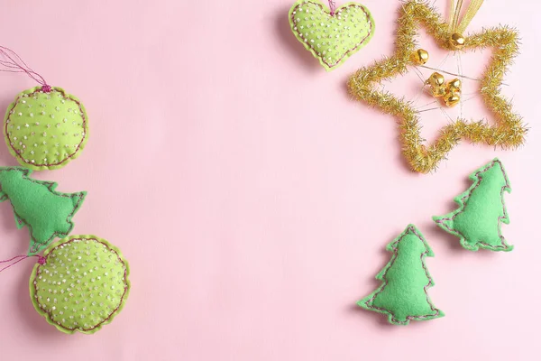 frame made of felt toys on a pink background. beautiful Christmas decoration in the form of a golden star. flat lay, holiday concept