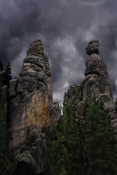 Two rocks with the dramatic stormy clouds in the background. National Park of Adrspach-Teplice rocks. Rock Town. Czech Republic