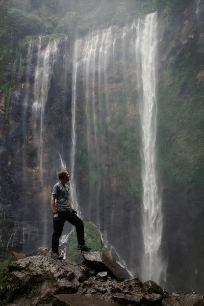 Şelalenin arka planında bir adam