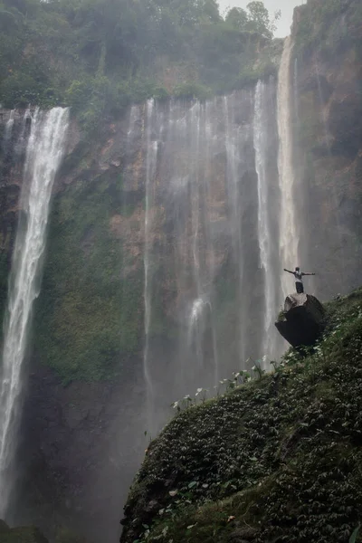 Şelalenin arka planında bir adam