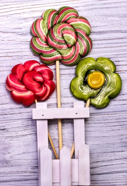 Lollipop candy flowers on a grey wooden background