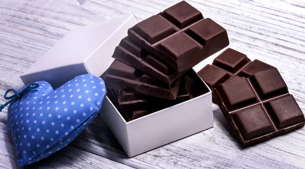 Barrette di cioccolato fondente in una scatola e cuore blu — Foto Stock