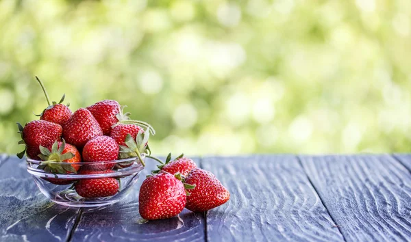 Red strawberries outdoors on an  table derevyannos — Stock Photo, Image