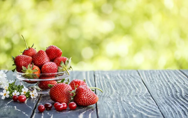 Red strawberries outdoors on an  table derevyannos — Stock Photo, Image