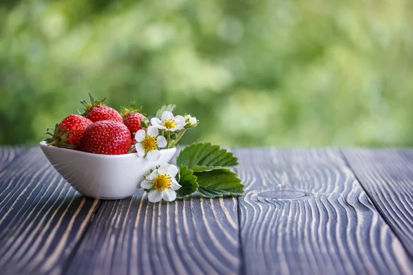 Fresas rojas al aire libre en una mesa derevyannos —  Fotos de Stock