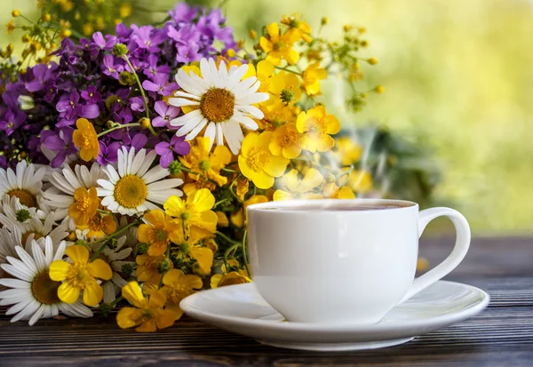 Taza de café y flores en la mesa de madera — Foto de Stock