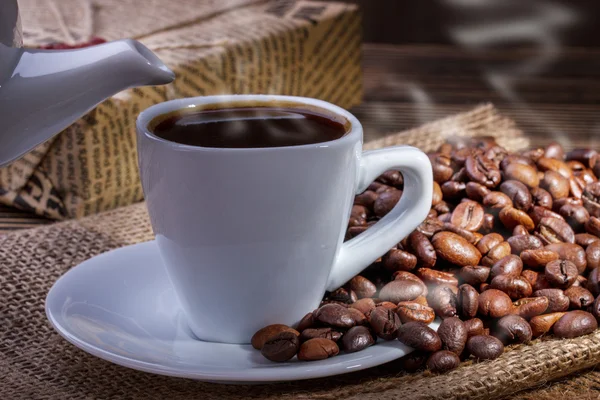 Taza de café y granos de café con humo —  Fotos de Stock