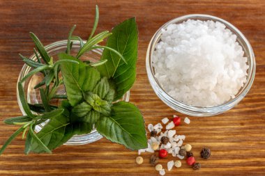 Deniz tuz kokulu ot biberiye ve nane yaprakları üzerinde ahşap backgro