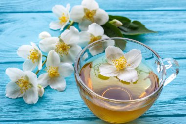 Yasemin çayı ve ahşap arka plan üzerinde Yasemin çiçekleri