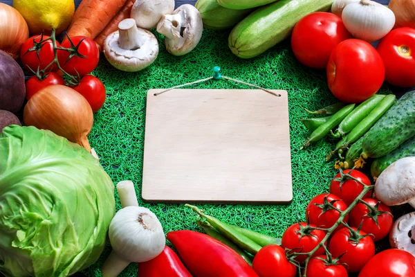 Färska grönsaker på en brun bakgrund med papper — Stockfoto