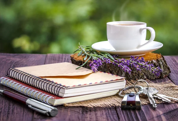 Libreta blanca en blanco, las llaves, manojo de lavanda y taza de café — Foto de Stock