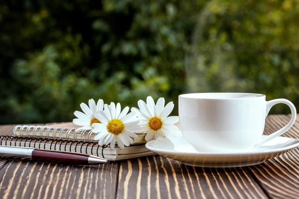 Cuaderno blanco en blanco, pluma y taza de café en el escritorio — Foto de Stock