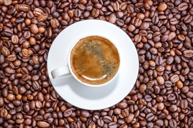 Kahve fincanı ve ahşap eski arka plan üzerinde kahve çekirdekleri.