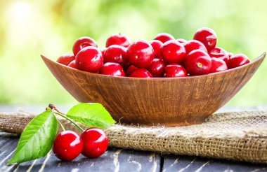 Bahçedeki ahşap masa üzerinde taze kiraz