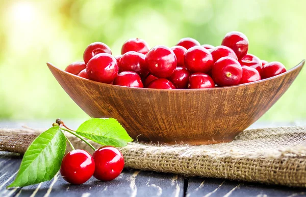 Bahçedeki ahşap masa üzerinde taze kiraz