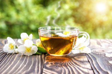 Yasemin çayı ve ahşap arka plan üzerinde Yasemin çiçekleri