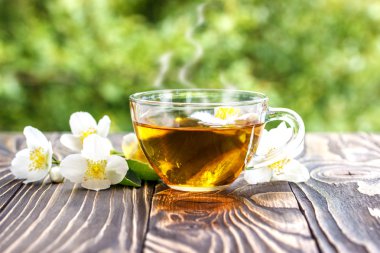 Yasemin çayı ve ahşap arka plan üzerinde Yasemin çiçekleri