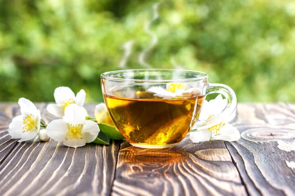 Yasemin çayı ve ahşap arka plan üzerinde Yasemin çiçekleri