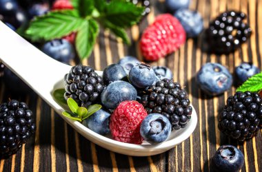 Ahududu, böğürtlen ve ahşap tahta üzerinde yaban mersini