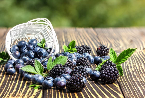 Blueberries and blackberries  on a  wooden table. — Stock Photo, Image