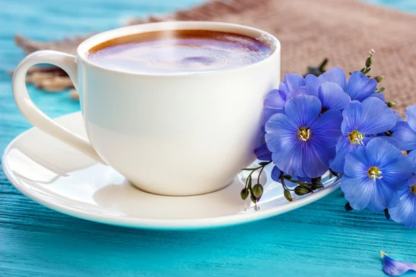 Taza de café con flores en la mesa rústica azul de arriba, desayuno — Foto de Stock