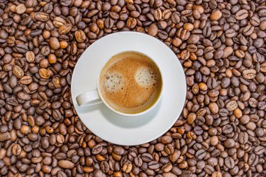 Kahve çekirdekleri üzerinde bir fincan kahve, üst manzara, arka plan.