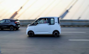 7 Aralık 2025, Panaji, Goa, Hindistan - Gündüzleri seyahat ve seyahat kavramları için metropoliten bir yolda seyreden gösterişli beyaz geçiş aracı.