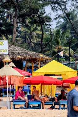 6 Aralık 2025, Panaji, Goa, Hindistan - Goa 'da bir sahil tatil beldesinde güneşli bir gün insanların plaj kulübelerinin ve şemsiyelerin gölgesinin keyfini çıkardıkları.